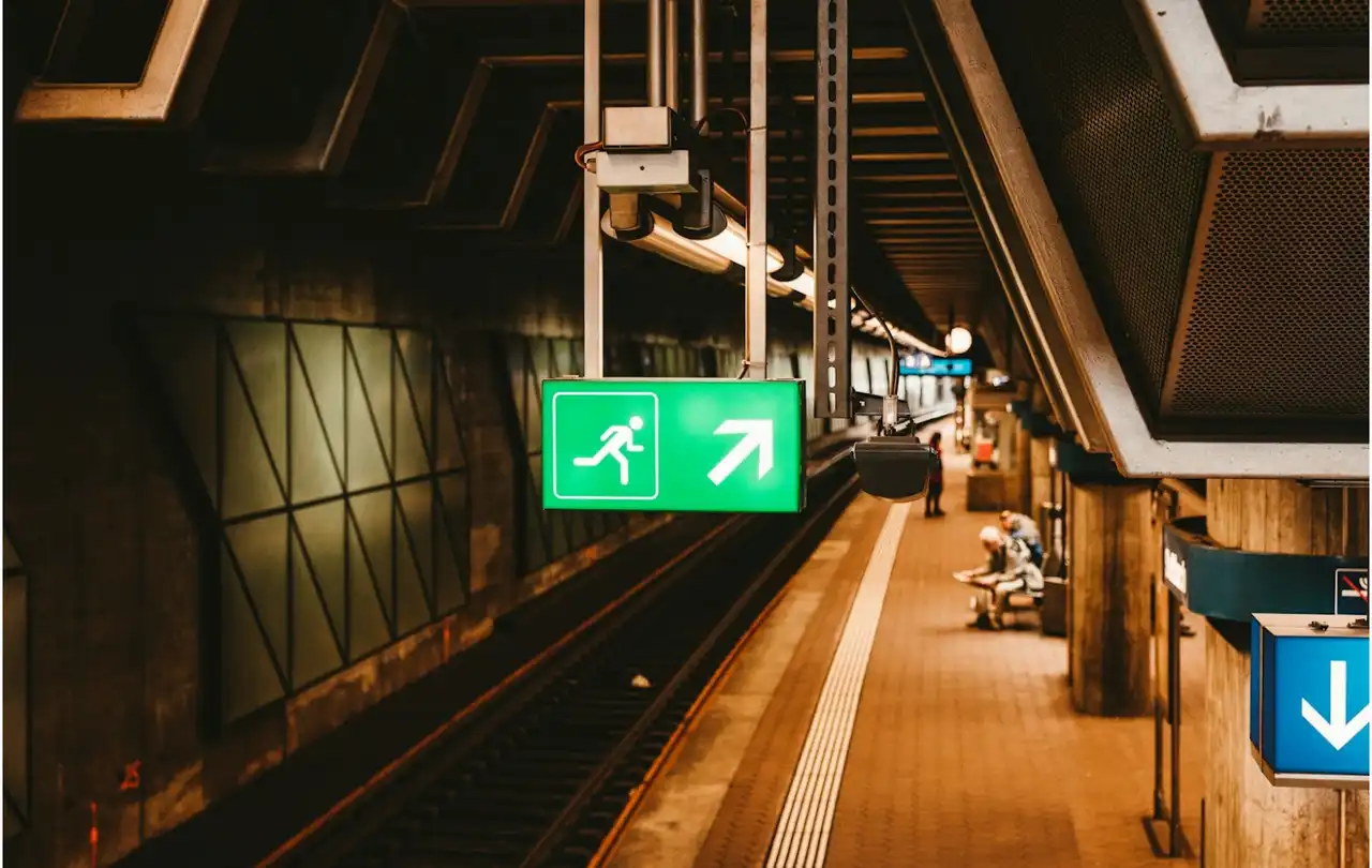 Emergency exit sign in a commercial transit station, representing life-safety systems supported by fire alarm cable and reliable low-voltage system performance
