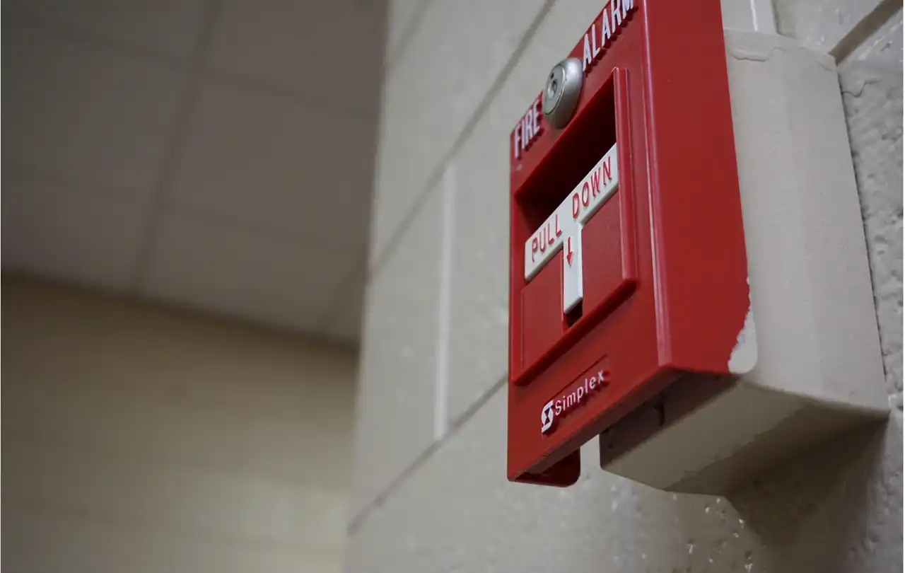 Fire alarm pull station mounted on a wall in a commercial building, representing life-safety systems supported by 2 hour fire cable and reliable signal continuity