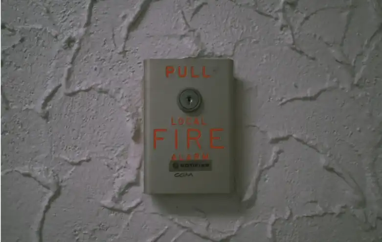 Wall-mounted fire alarm pull station used in commercial fire alarm systems illustrating life safety signaling devices connected by fire alarm cable and wiring