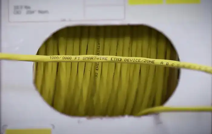 SmartWire cable exiting a dispenser box with sequential footage markings printed on the jacket for easy run planning.