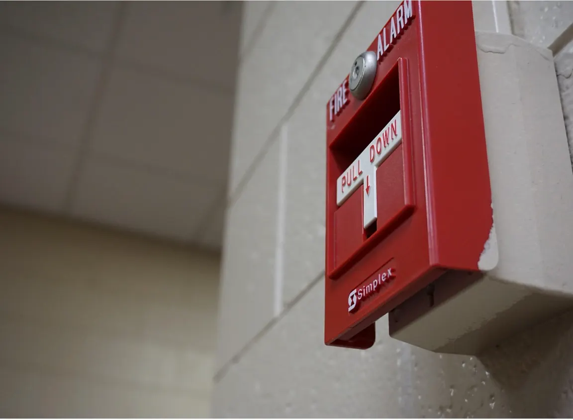 Fire alarm pull station mounted on a wall in a commercial building, representing life-safety systems supported by 2 hour fire cable and reliable signal continuity