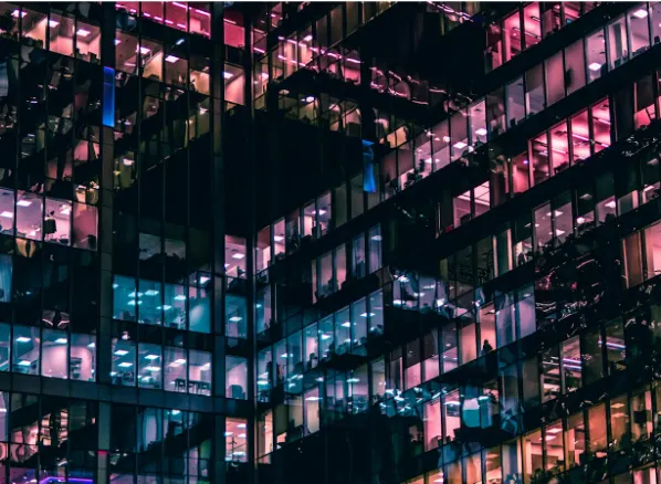 Modern office building with illuminated windows representing large commercial networks where LAN cable distance and Ethernet cable length limits affect structured cabling performance