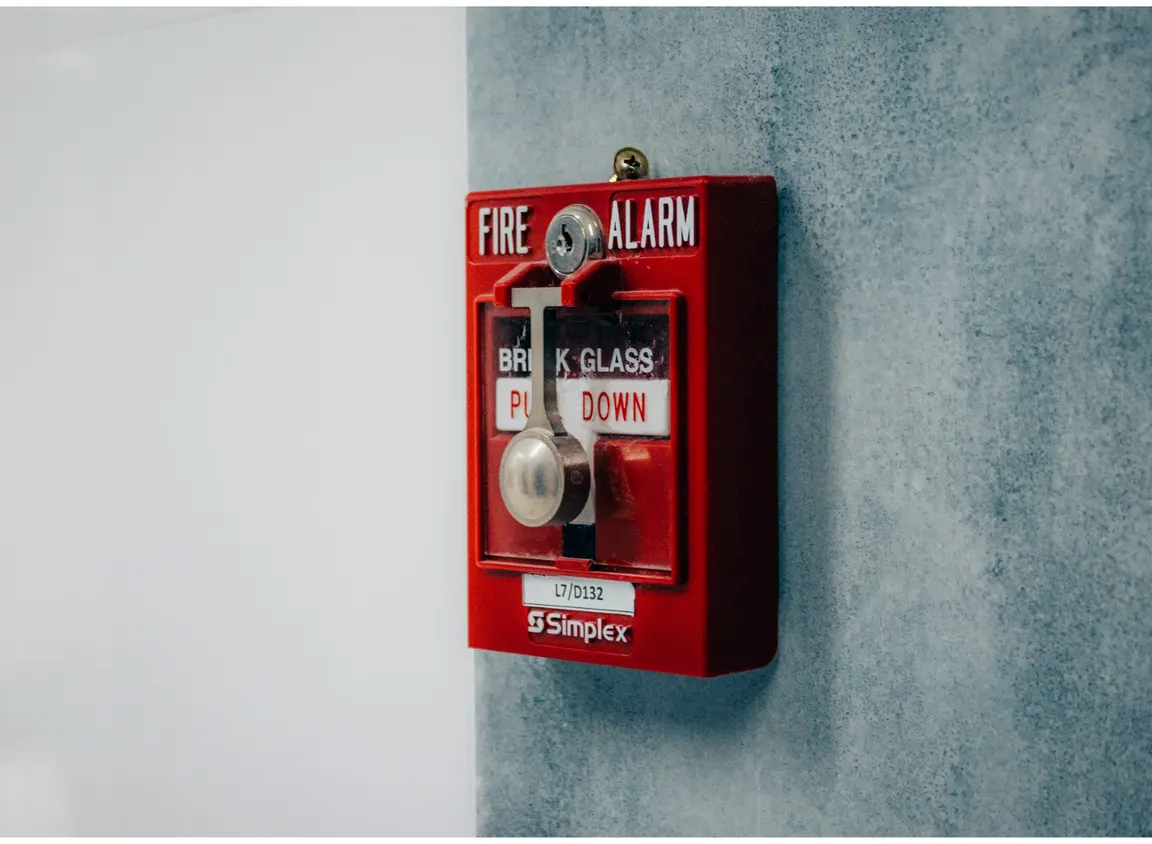 Fire alarm pull station mounted on wall, representing commercial fire alarm systems where 14 AWG fire systems wire supports reliable signal and power distribution