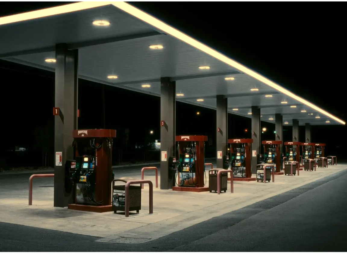 Commercial gas station fuel dispensers at night representing petroleum environments where shielded FEP control cables support dispenser communication and control systems