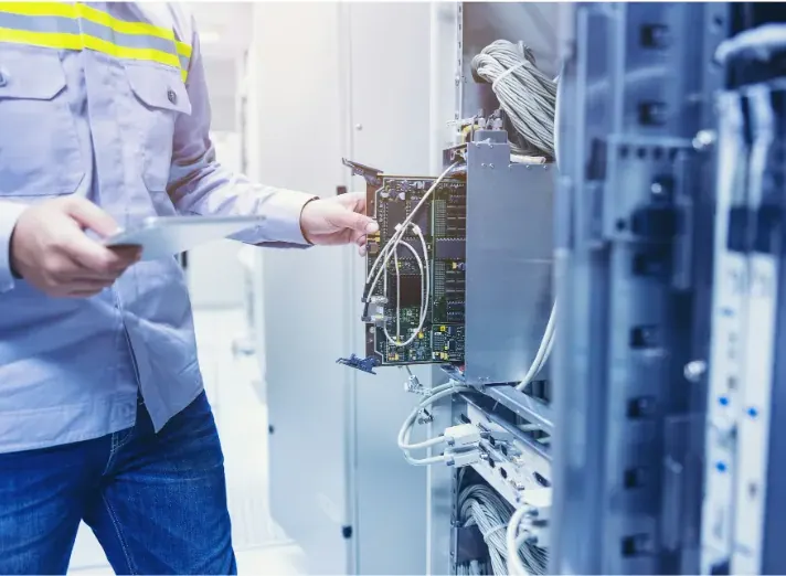 Technician servicing a commercial network cabinet with structured cabling, illustrating enterprise infrastructure where Cat6a and Cat7 support high-speed data transmission and reliable network performance