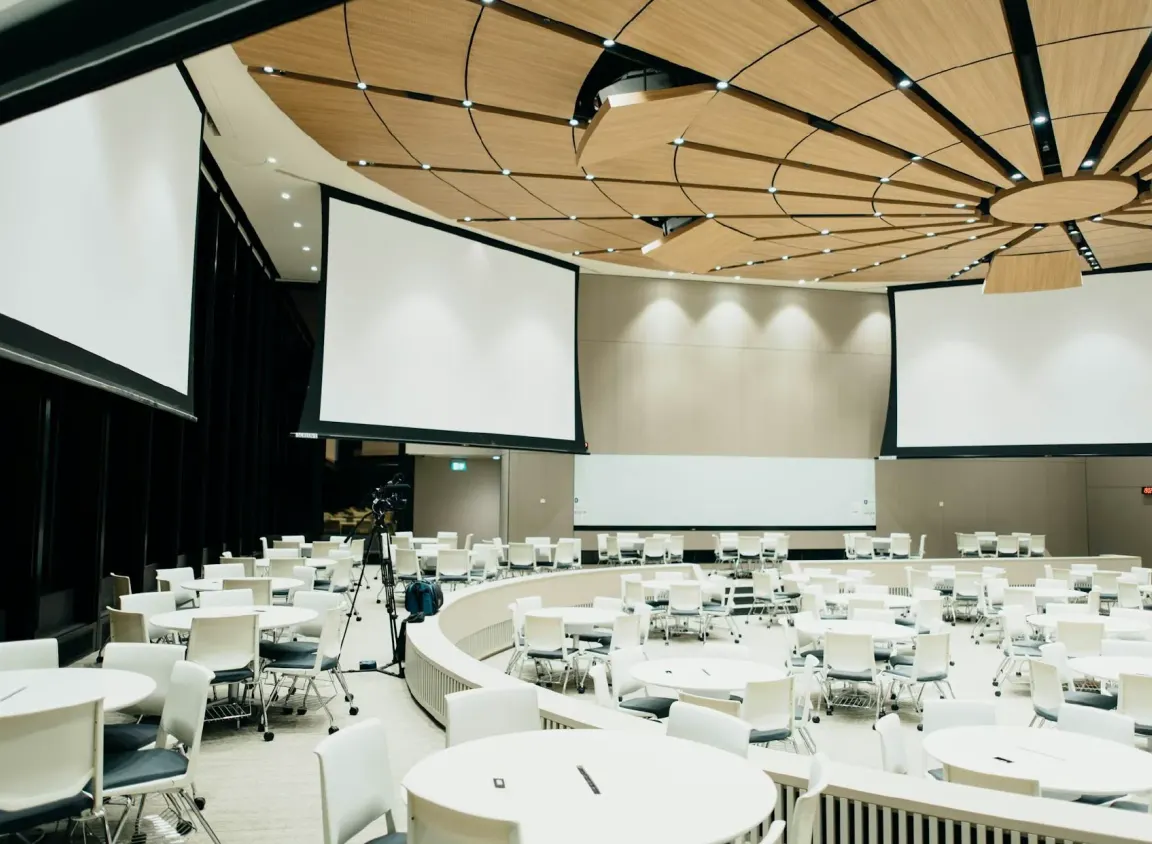 Modern commercial conference center featuring multiple large projection screens and AV infrastructure used for video distribution and network-connected presentations.