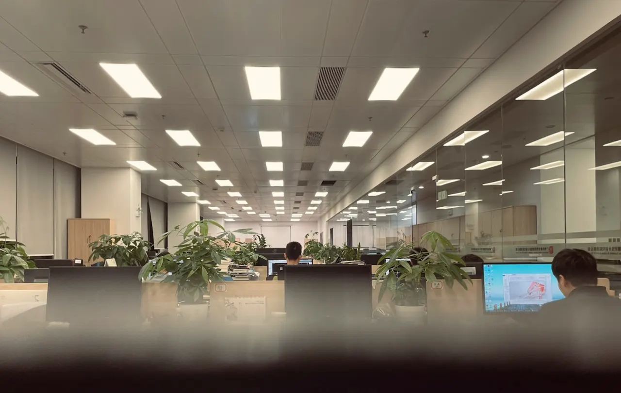 Commercial office lighting control environment with ceiling LED fixtures and networked workstations, illustrating a structured Lutron control system that relies on twisted-pair communication cable and proper jacket ratings for reliable performance.
