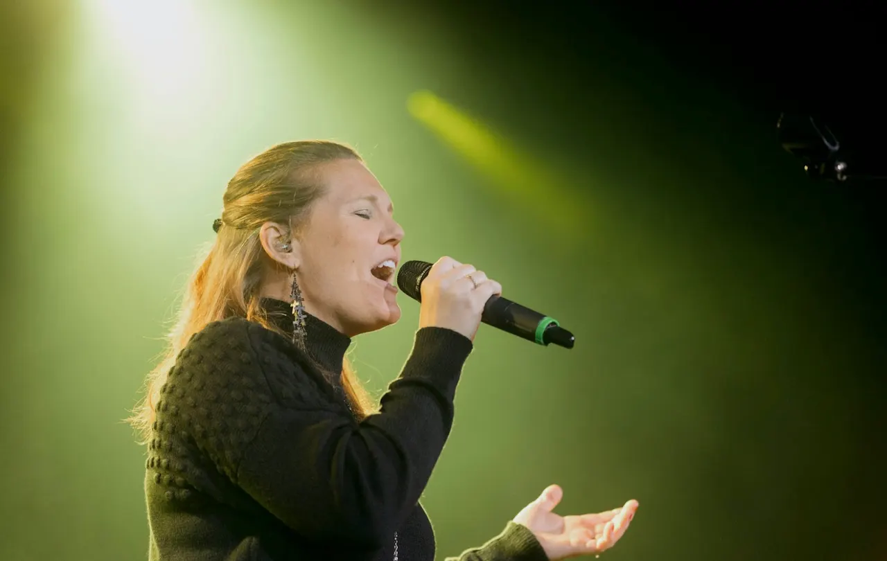 Performer using a wireless microphone in a professional audio system where mic line cabling supports the signal path.